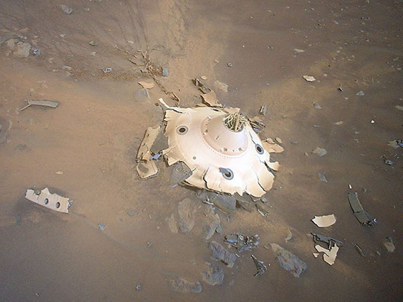 Mars Helicopter: Shattered cone-shaped metallic object on rocky ground.