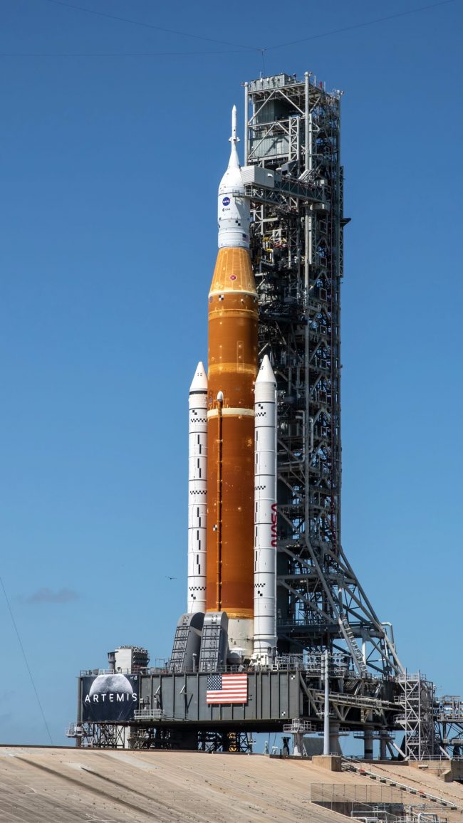 SLS dress rehearsal: Tall rocket with capsule atop and 2 booster rockets attached to the sides.