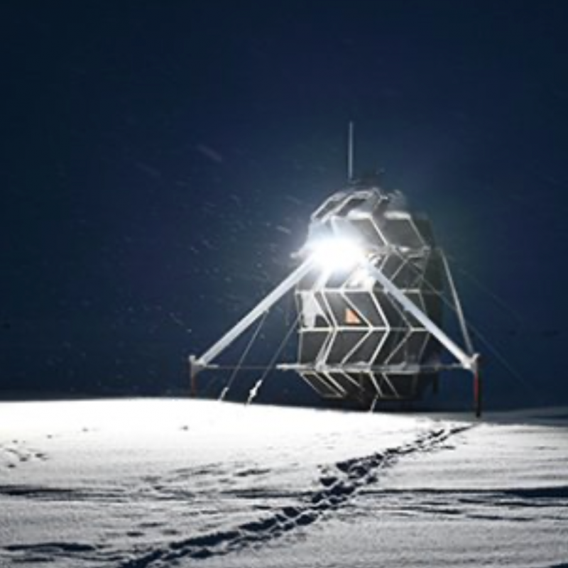 Moon habitat: Oddly-shaped vertical structure sitting on snow in darkness.