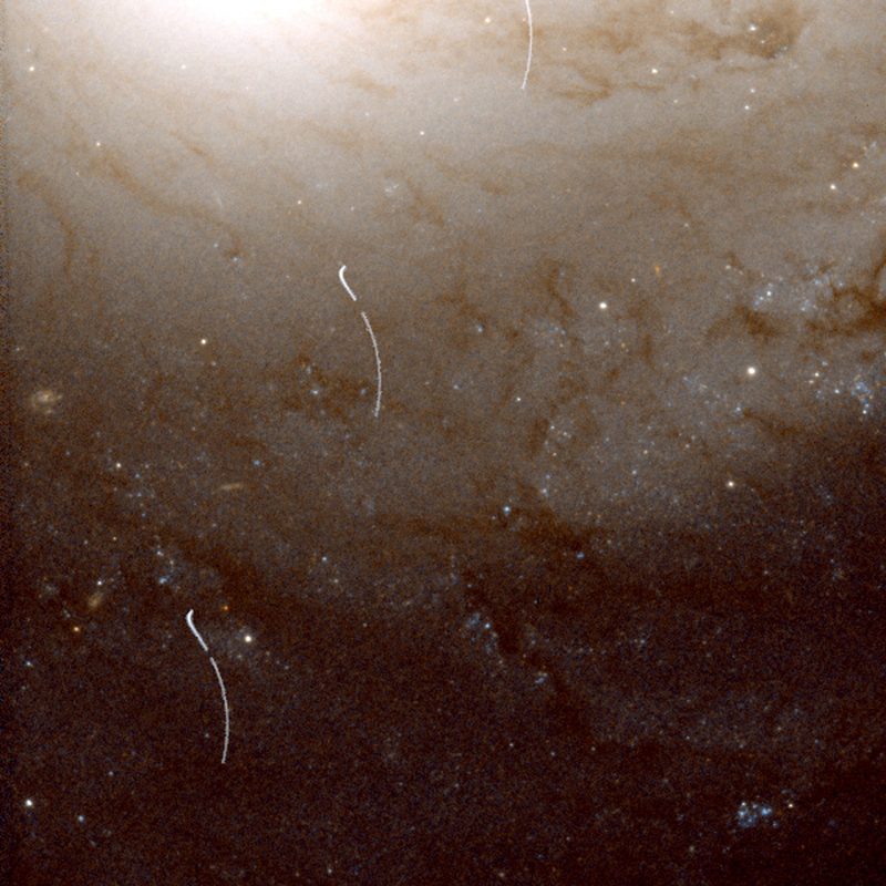Section of galaxy, bright center at top, fading downward, with thin white arcs against it.