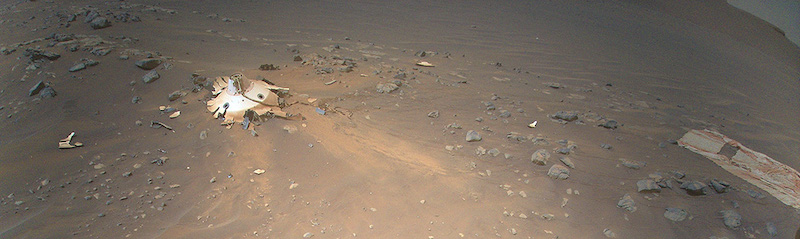Shattered conical metallic object with piece of cloth-like material nearby.