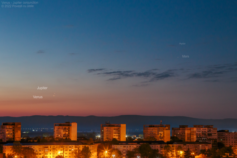 Four bright planets at dawn over an urban foreground.