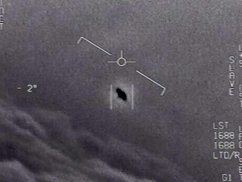 UFO hearing: Small oblong black object at angle on gray background, with tick marks showing plane attitude.