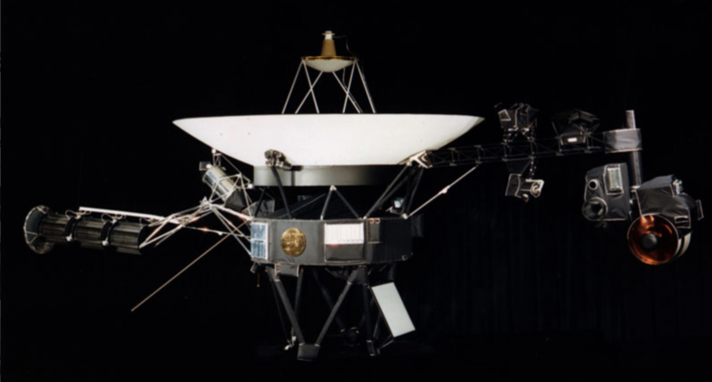 A complex spacecraft with a large dish antenna on a black background.
