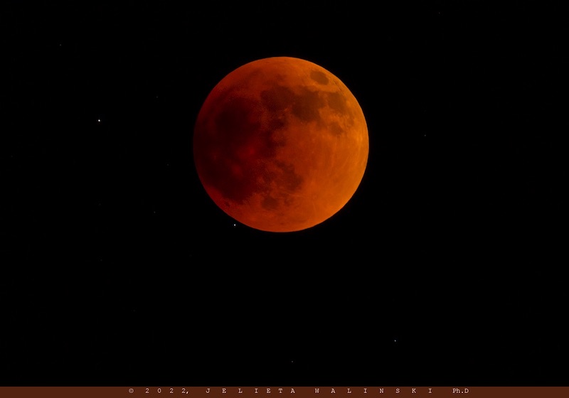 Deep red full moon against black background.