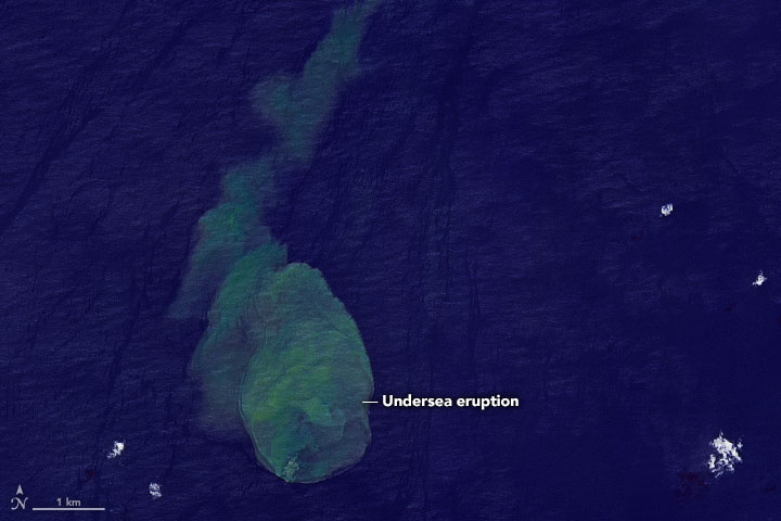Sharkcano: Greenish blob surrounded by dark blue sea from above.