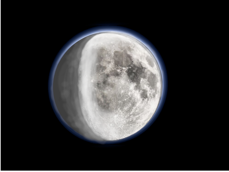 Moon water: Sunlit moon with white areas on surface and thin fuzzy layer of atmosphere.