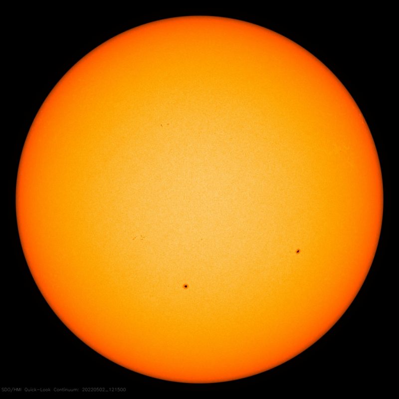 Grand solar minimum: Orange globe of sun, with 2 large spots.
