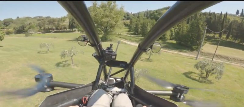 Hoverbike: View past struts at ground and trees below, with spinning rotors visible at the sides.