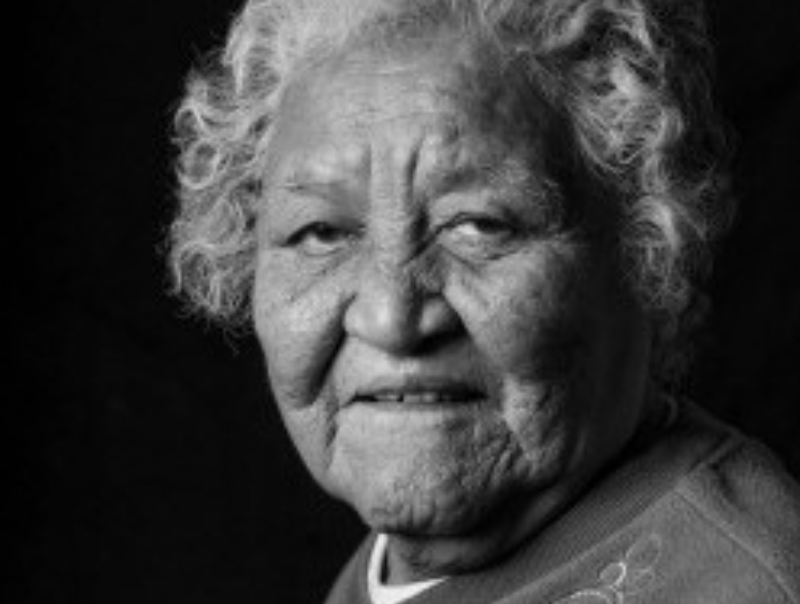 Older woman, rather stern, with curly white hair.