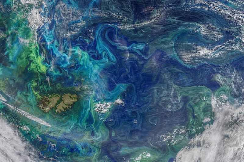 Orbital view of part of ocean with complex swirls of blue, teal, and gray.