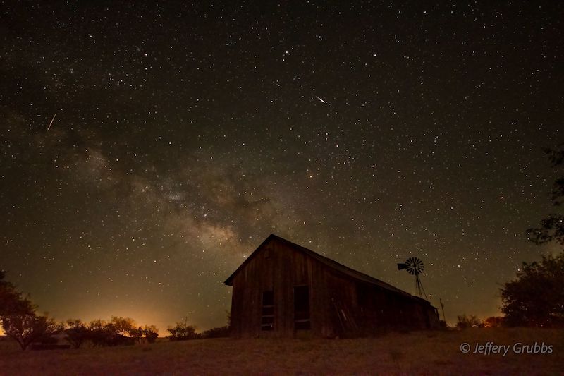 Barn against a starry night sky.
