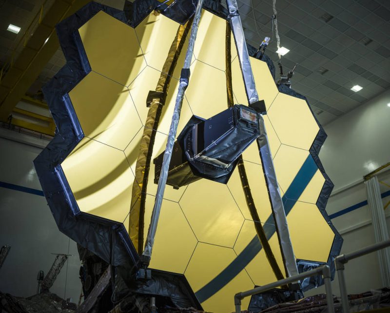 Early Webb images: Large telescope made up of individual hexagonal segments with an antenna in the middle.