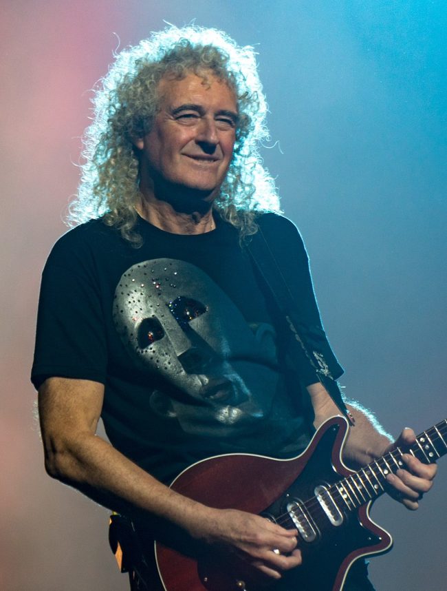 Floating in Heaven: Older rock musician playing an electric guitar, and smiling.