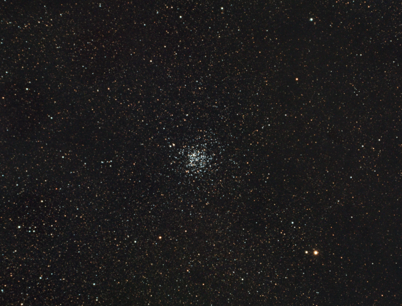 Tight cluster of many dots of white light in a star field.
