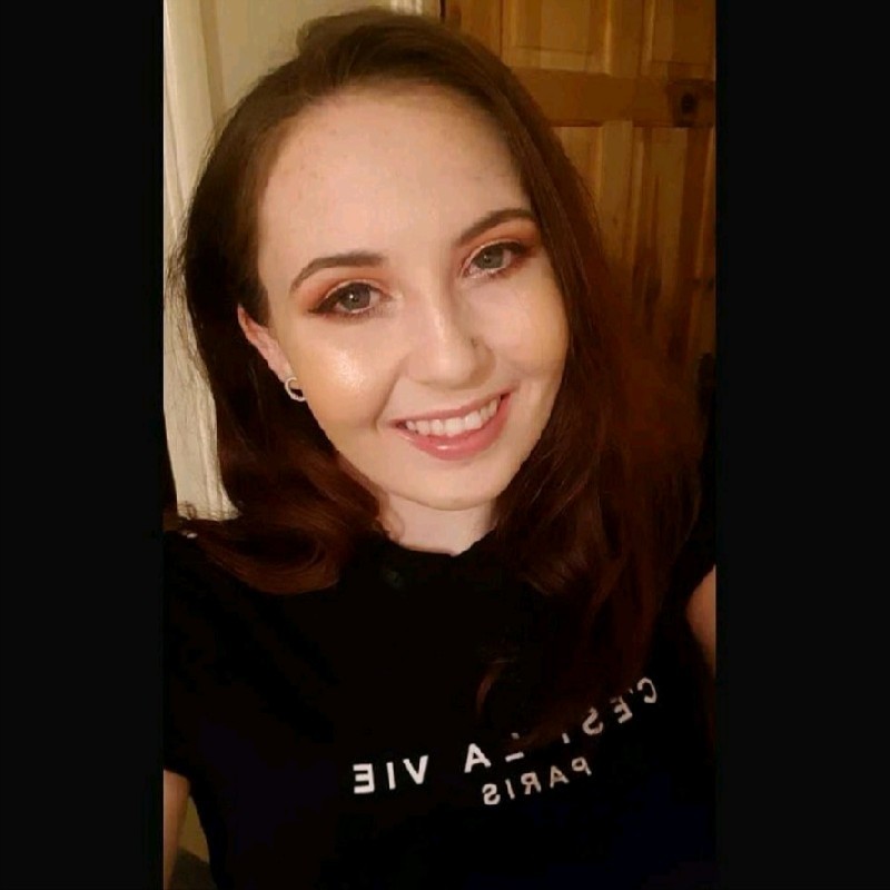 Smiling woman wearing black t-shirt with white lettering.