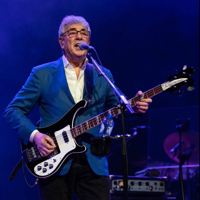 Older man playing an electric guitar and singing.