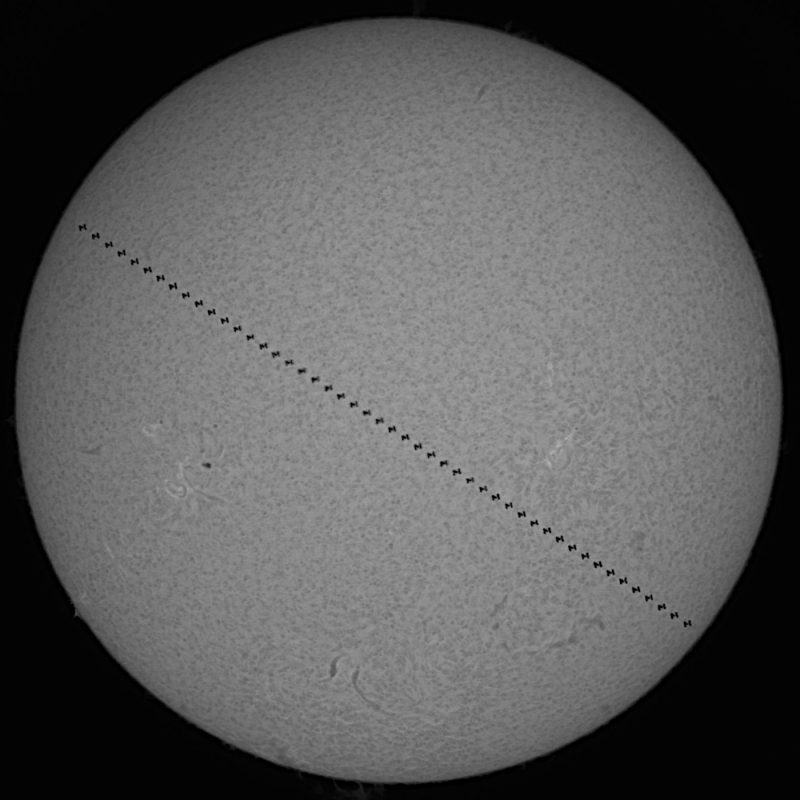 Gray globe (the sun) with dotted line across it from top left to bottom right (the ISS moving across the sun)