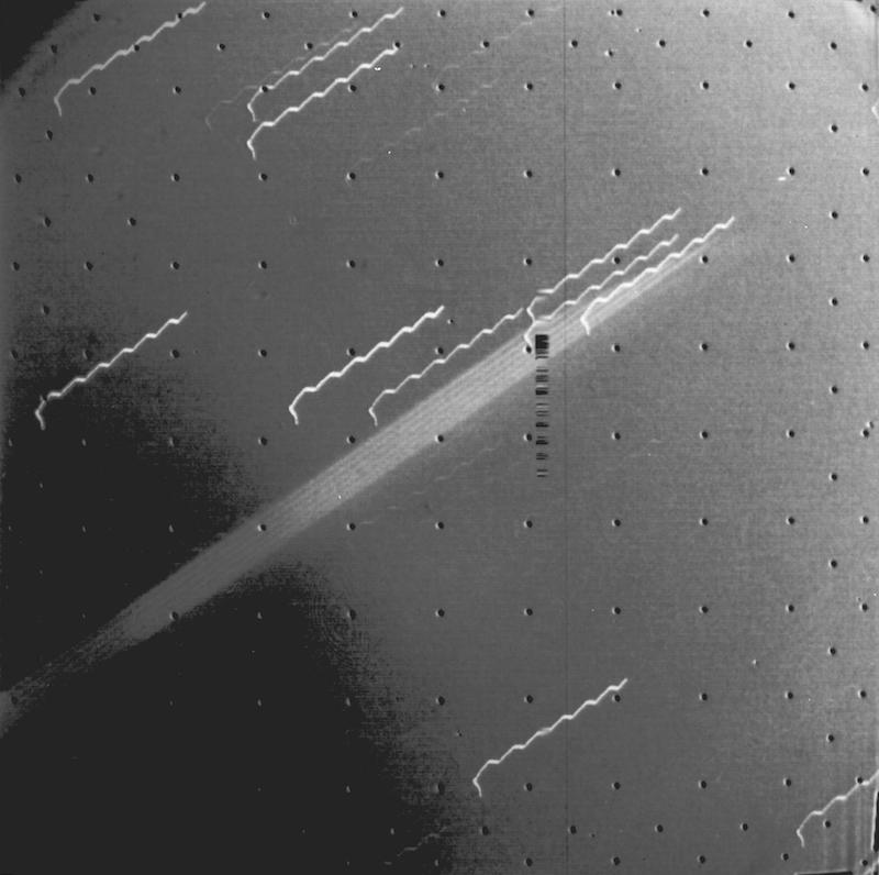 Long diagonal bright band crossing image with shorter streaks parallel to it.