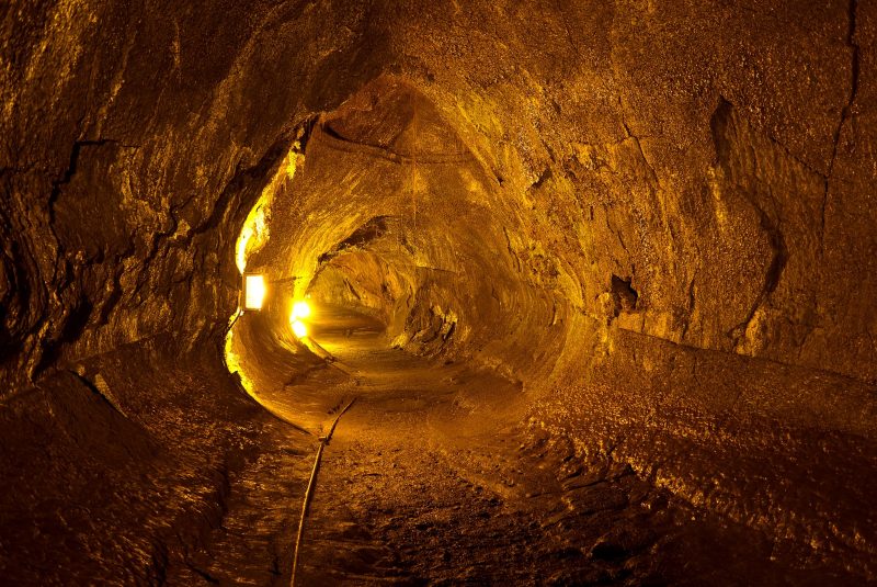 A cylindrical cave lit with lanterns casting a yellow glow.