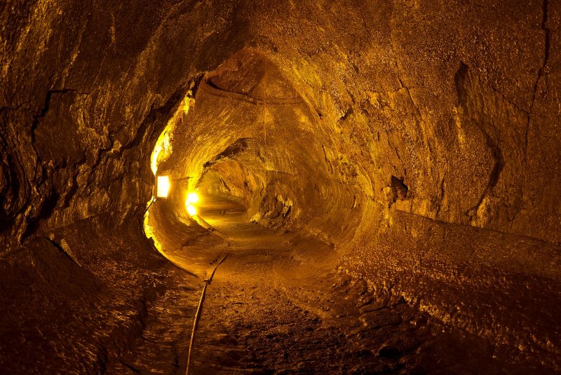 Cueva cilíndrica iluminada con linternas de color amarillo brillante.