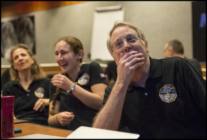 New Horizons: 3 people laughing and looking at out-of-sight screen.
