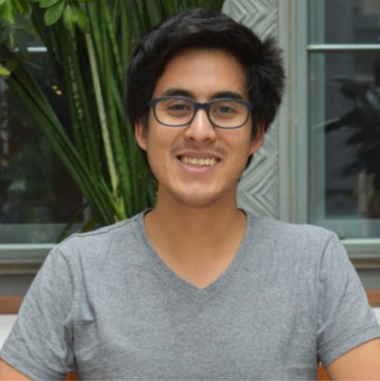 Young man in gray t-shirt and glasses, with thick black hair and thin mustache.