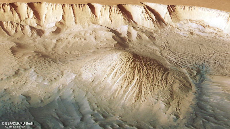 Deep canyon with sharp ridges and roundish mound on the valley floor.