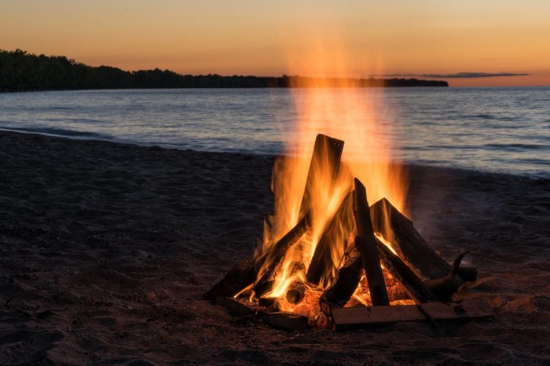 Humans tame fire: Campfire on a beach.