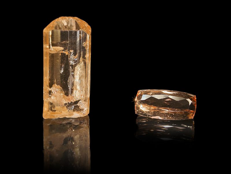 November birthstone: Two golden colored, transparent colored gemstones, one a natural crystal and one faceted.