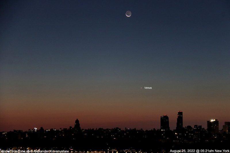 Sunrise hues with city below and crescent moon above plus Venus lower.