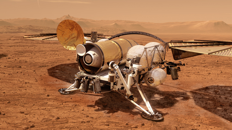 Robotic lander with 2 large solar panels sitting on reddish terrain.