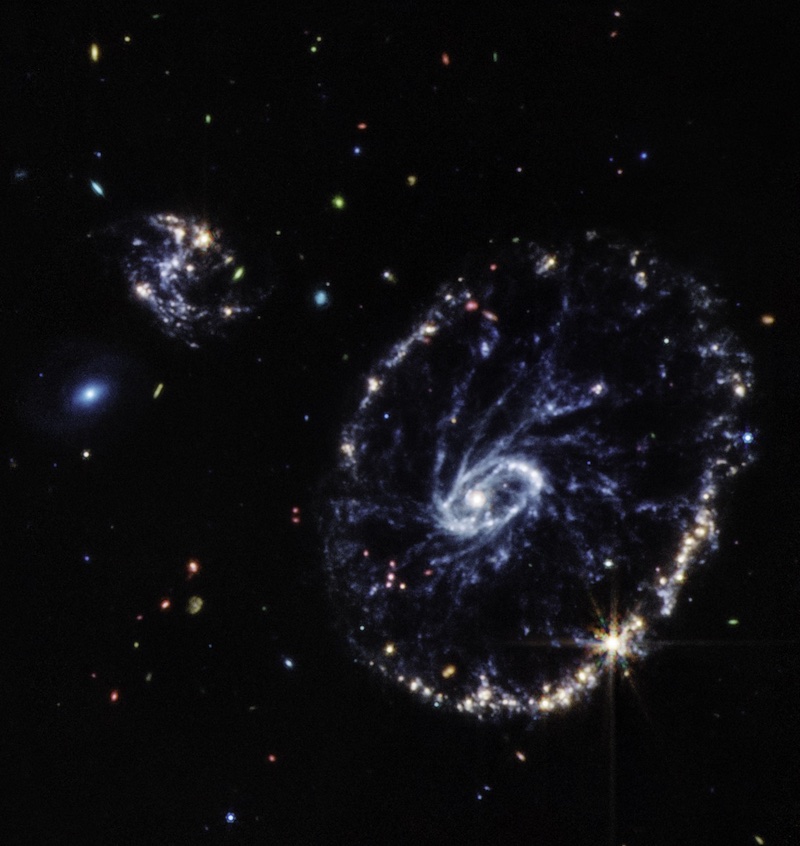 Large oval galaxy with spoke-like arms and other galaxies nearby.