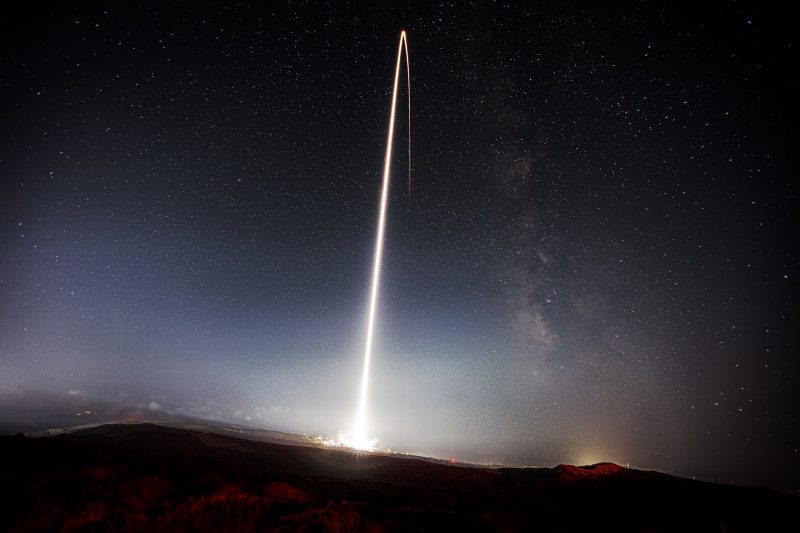 Rocket trail leaving Earth, curving.