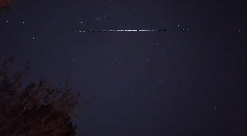 Starlink: Night sky with dashed line of lights horizontally at top.