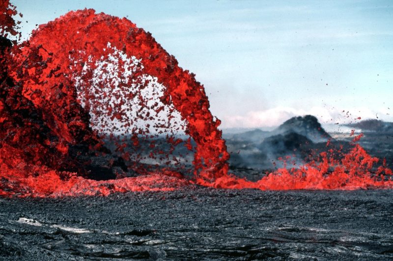 Mega volcanoes caused mass extinctions: Arcing red eruption of volcanic material onto thick ground.