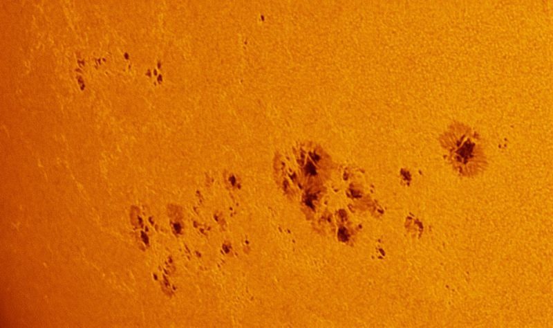 The sun, seen as a magnified yellow surface with a mottled surface.