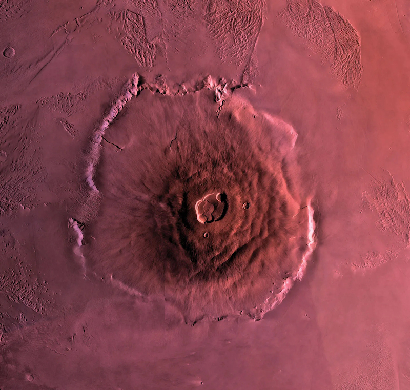 Is Mars volcanically active? Overhead view of large volcano on reddish terrain.
