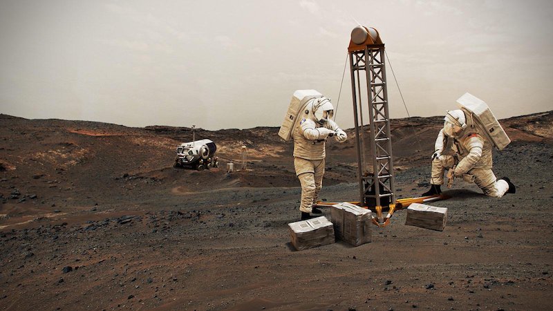 2 astronauts on reddish terrain under white sky with tall drill and rover in background.