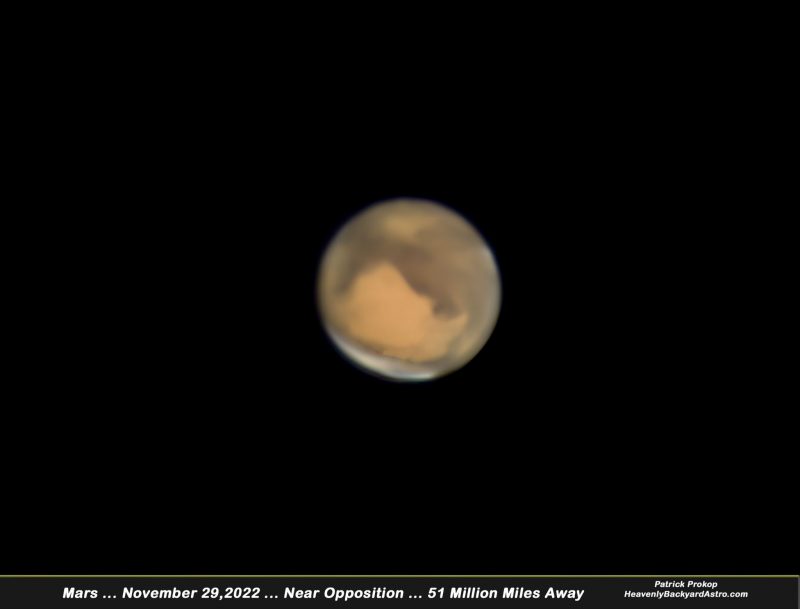 Mars as orangish ball with dark and light markings and white at south pole.