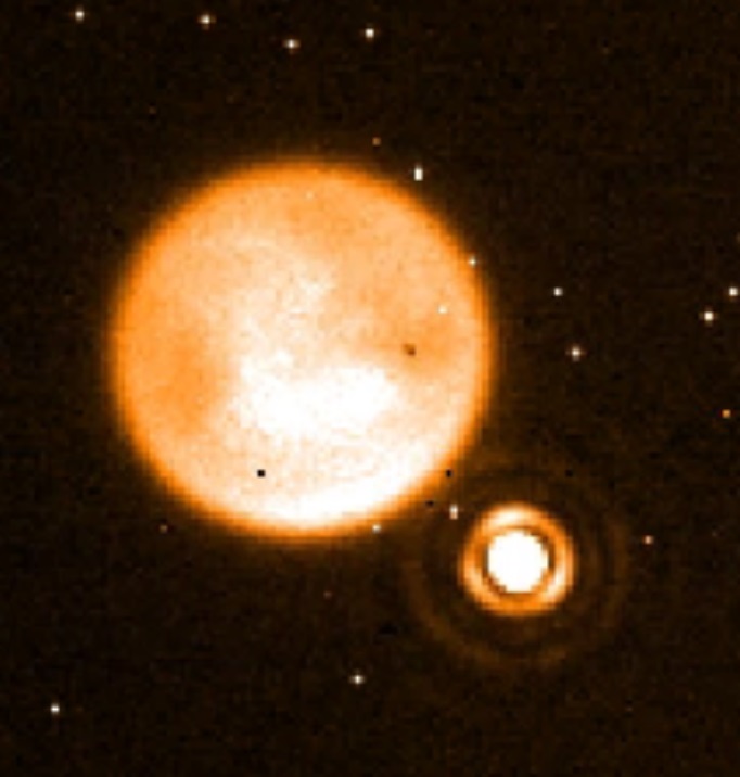 Round orangish ball (Titan) with small ringed circle to lower right (star).