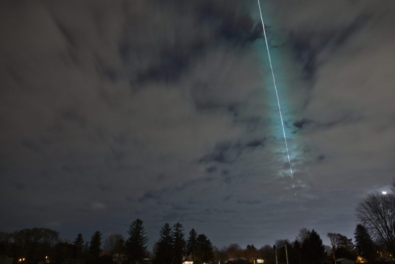 Asteroid impact: A streak of green light through the clouds.