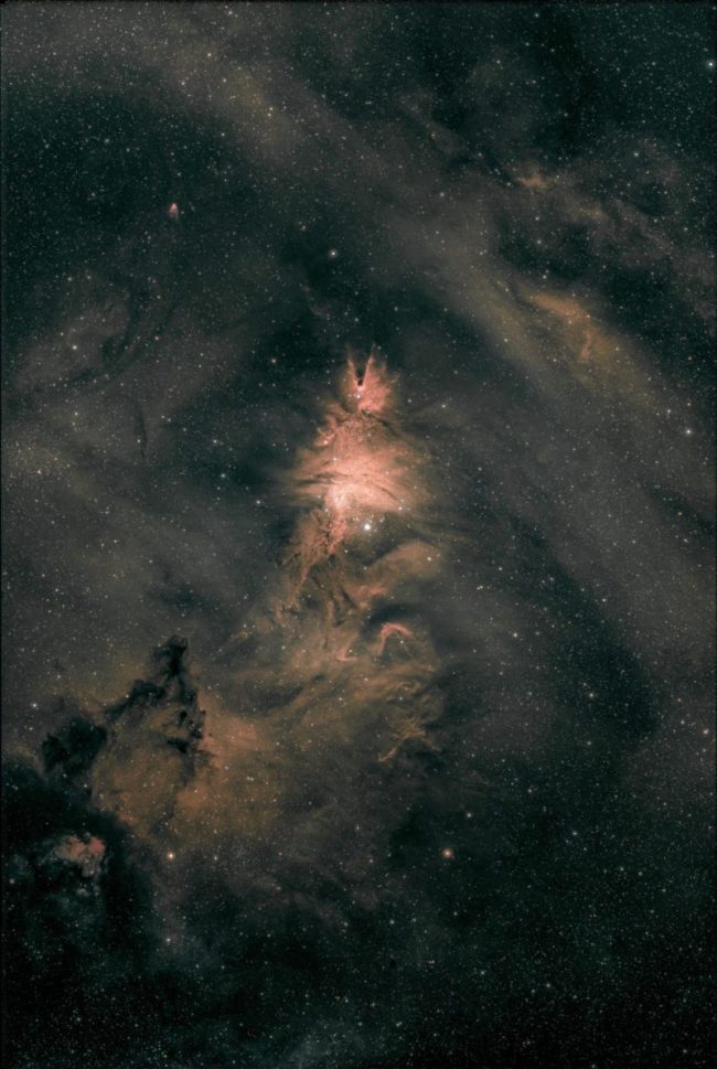 Large swirls of orange nebulosity over a background of distant stars.