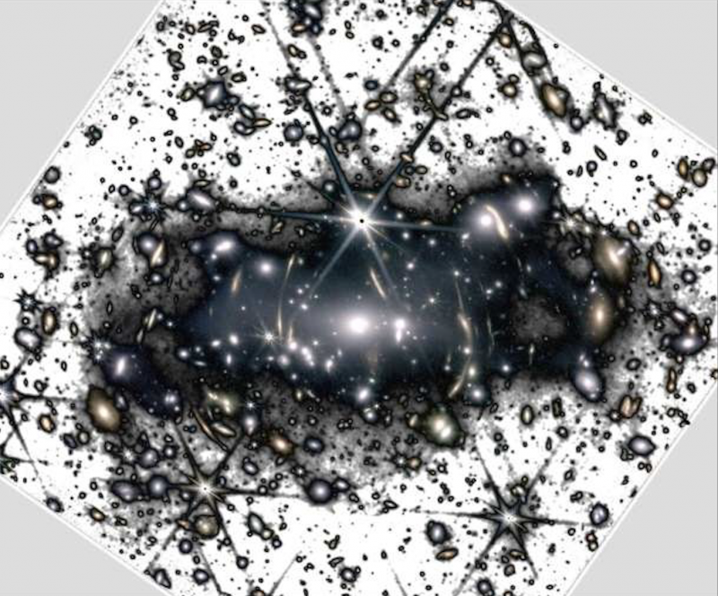 Ghostly light in galaxy clusters: Black and white negative image of a galaxy cluster, with fuzzy darkness between the very many galaxies.