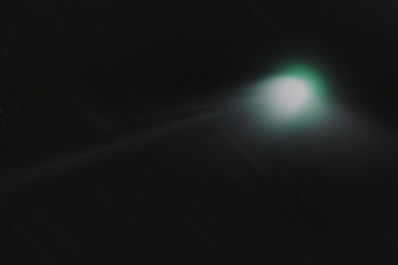 Bright glowing fuzzy object with a streamer coming off it.
