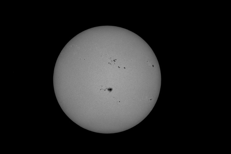 The sun, seen as a large gray sphere with small dark spots.