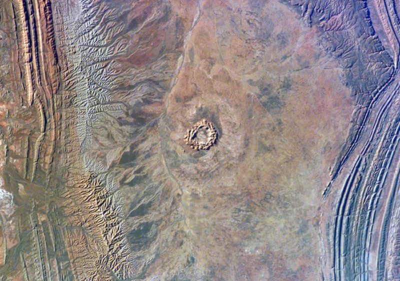 Impact craters on Earth: Landscape from above with round pockmark and rings.