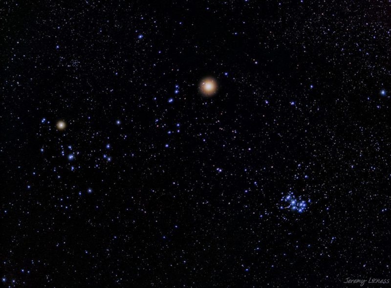 A multitude of blue background stars with two bright, reddish, star-like objects.