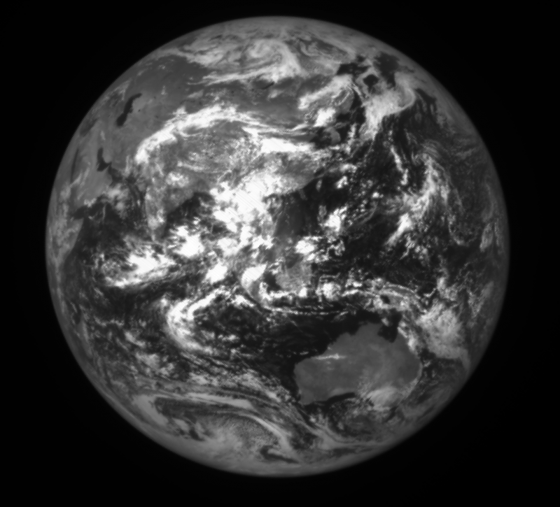 Black and white full Earth showing many bright clouds over East Asia.