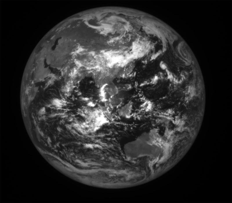 Black and white full Earth showing many bright clouds over East Asia.